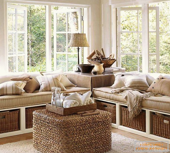 A small veranda of closed type is decorated in the best traditions of eco-style. Window sills are involved and are kind of sofas.
