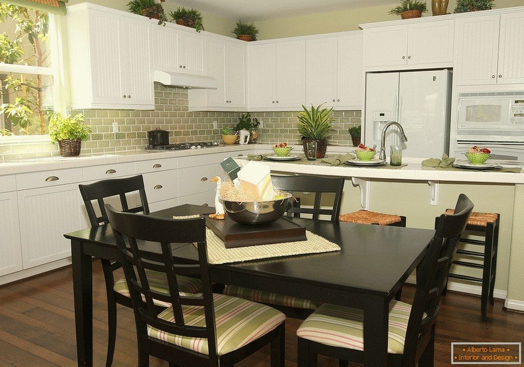 Black table with chairs and white furniture in the kitchen