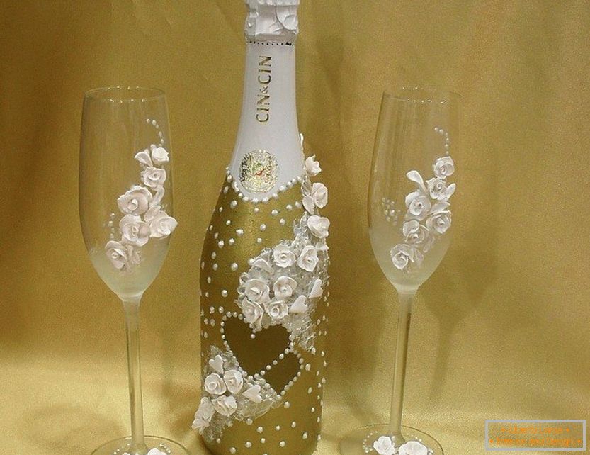 Decor of a bottle and wine glasses with roses and beads