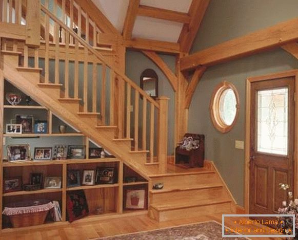 Staircase of wood on the second floor in the design of the living room of a private house