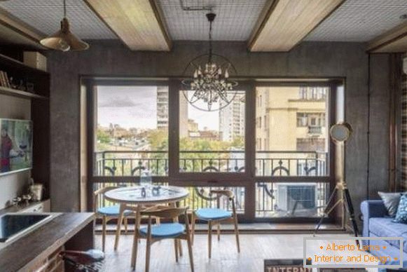 The kitchen design of the living room in the interior of the studio apartment of 40 sq m in the loft style