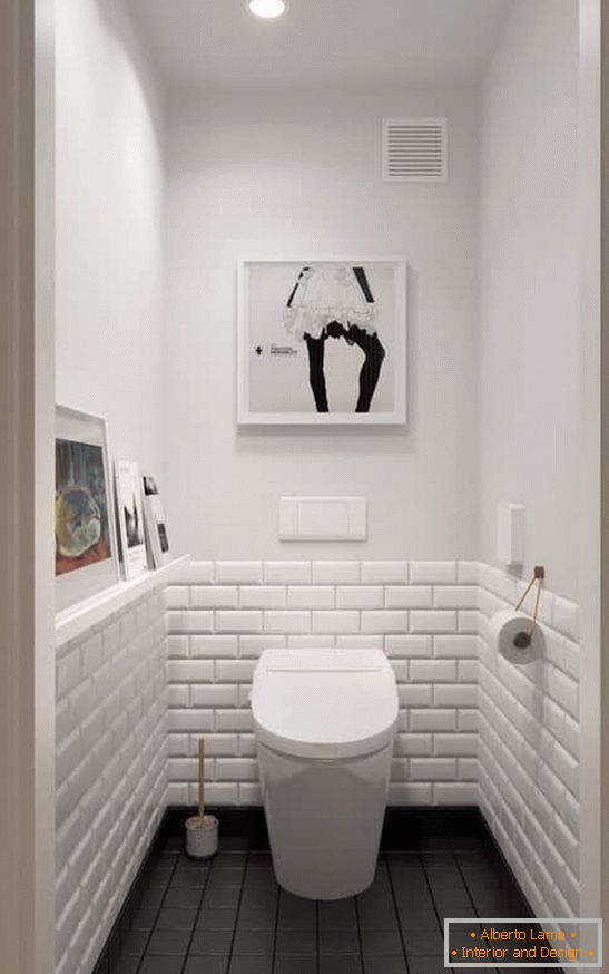 A small toilet in white with a dark floor