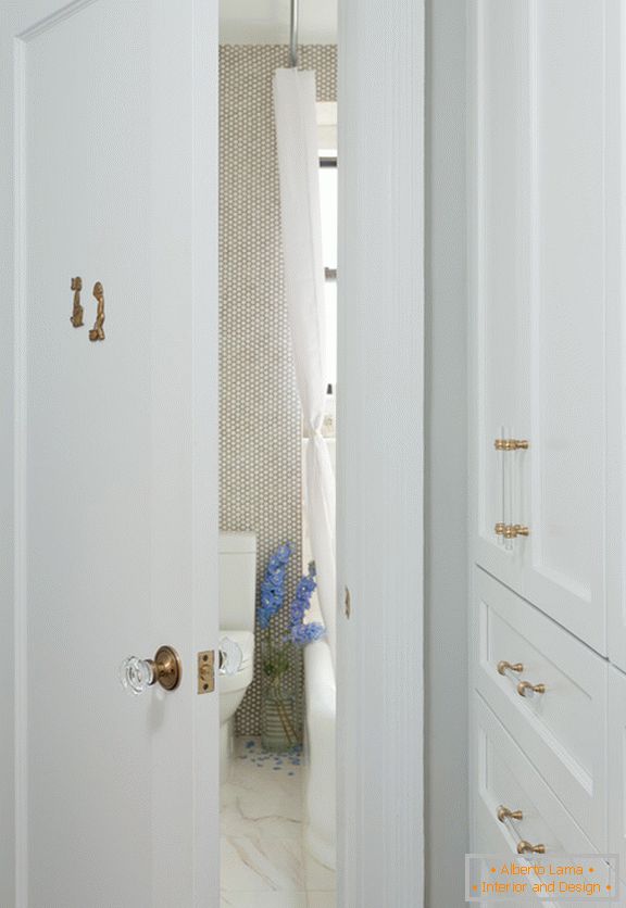 White door to the bathroom with a marble floor
