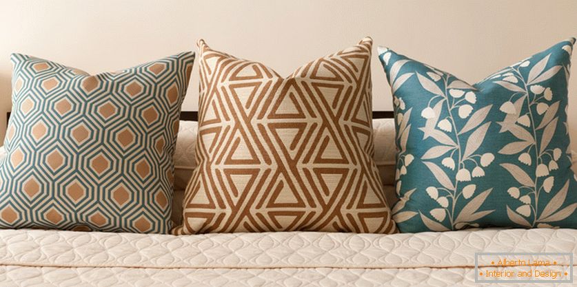 Decorative pillows on the bed in pastel-turquoise tones