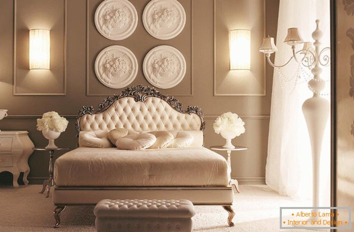 At the head of the bed, the wall is decorated with a composition of designer stucco. Exquisite bedroom decoration in the Art Deco style.