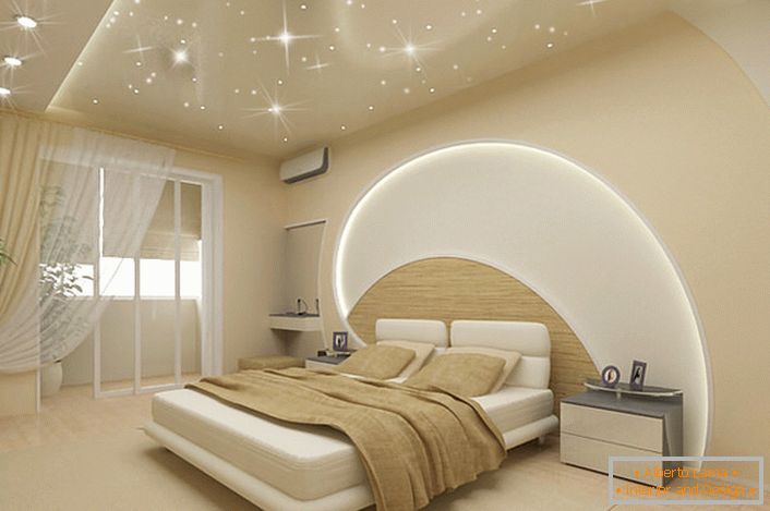 Attention attracts the decoration of walls and ceiling in the bedroom in a modern style. LED stripes pass through the ceiling and the wall above the bed, stretch ceilings mimic the magical starry sky.