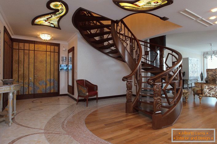 The hall in the modern style with a spiral staircase to the second floor is equipped with