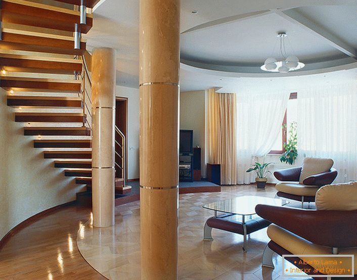 A spacious, bright living room under a staircase in a two-level apartment. 