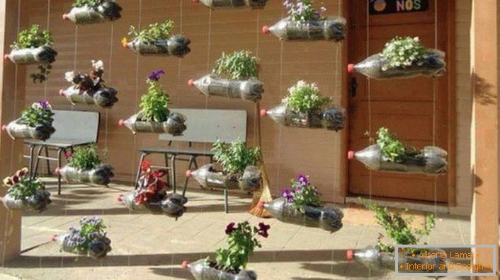 An artificial curtain for the veranda of a house from mini-flower beds in plastic bottles. To make the composition look even more attractive, the bottles can be painted in different bright colors. 