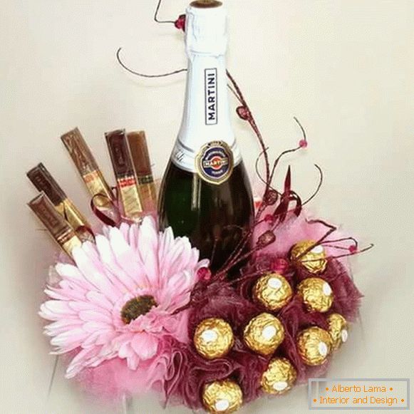 Decor of a bottle of champagne with candies and flowers - photo