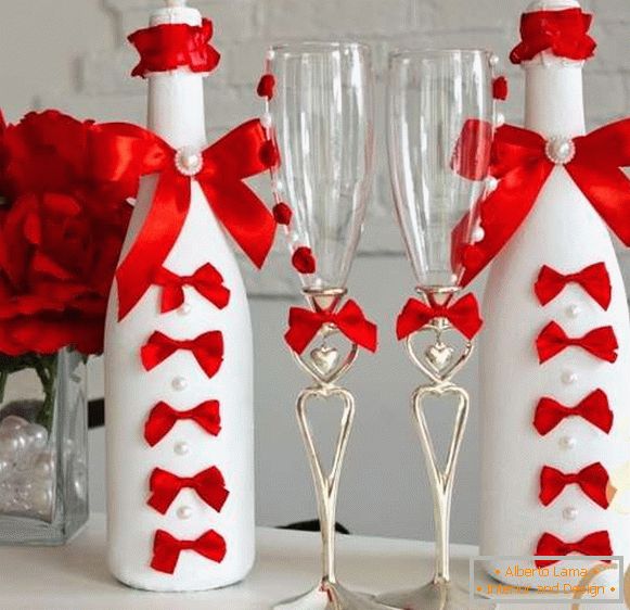 Decor of a bottle of champagne for a wedding with ribbons and beads