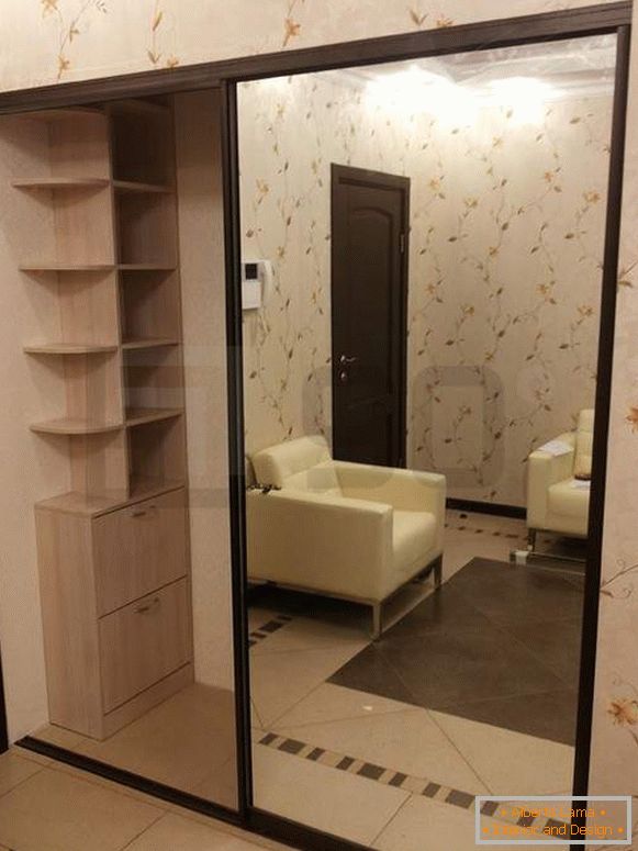 Built-in wardrobe compartment with mirror doors in the interior of the hallway