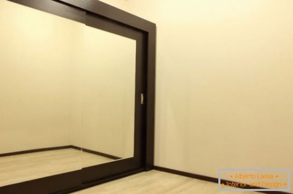 Built-in wardrobe with mirrored doors and wood trim