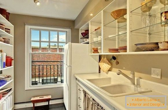 Open glass shelves with crockery in the interior of a small kitchen