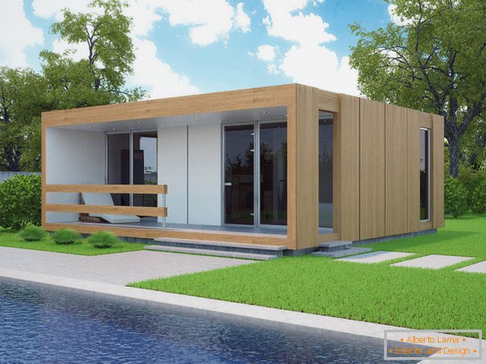A small modular house with a swimming pool in the yard. The stylish design of a house that is being built quickly looks organically against the background of a short cropped lawn.