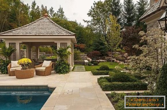 Swimming pool on a section of a country house with a gazebo and a sitting area