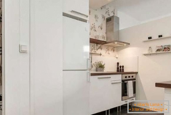 Design of a small kitchen in the interior of the studio apartment in white tones