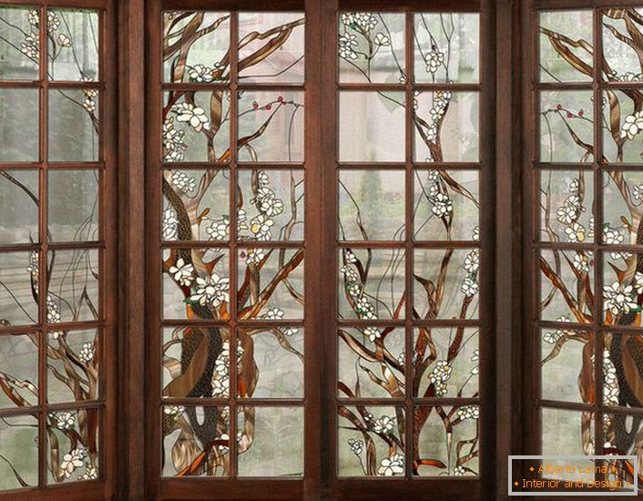 The windows in the dark wooden frame are decorated with stained glass. Uncomplicated figure suitable for interior design in the style of country or modern.