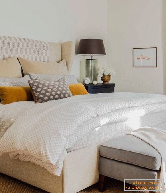 Interior of the bedroom in beige colors with the addition of gray and orange