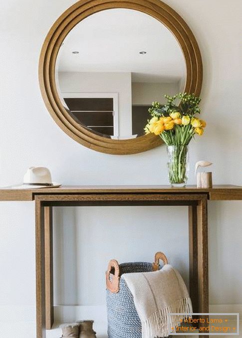 Round mirror in the hallway with wood trim