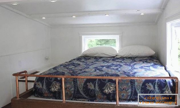 Bedroom under the ceiling in a small house on wheels