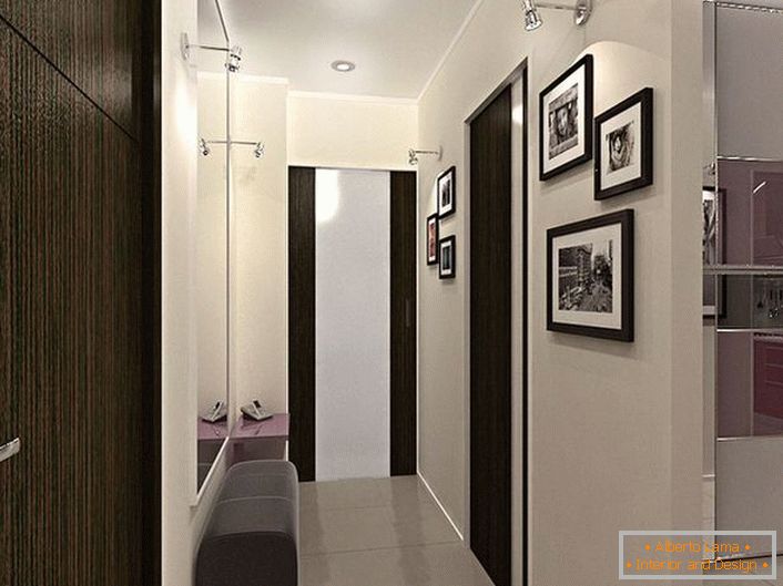 Design solution for a narrow hallway. Decoration in contrasting white and dark brown colors, not only looks stylish, but also visually makes the room more.