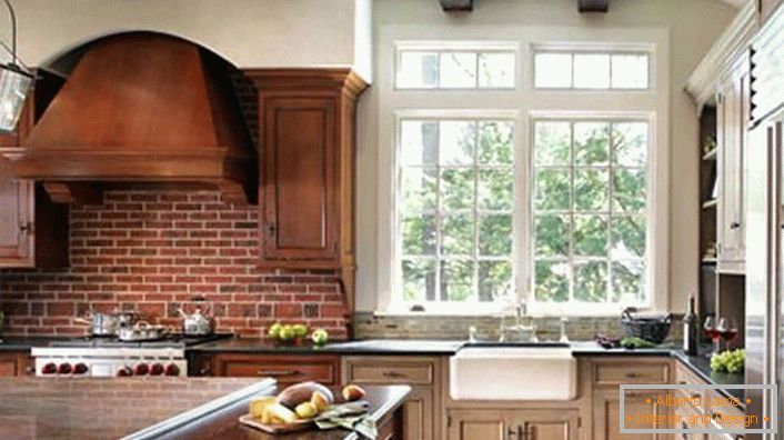 Correctly decorated kitchen in a rustic style. The hood and dark wood cabinets are combined with a wall, laid out of bricks.