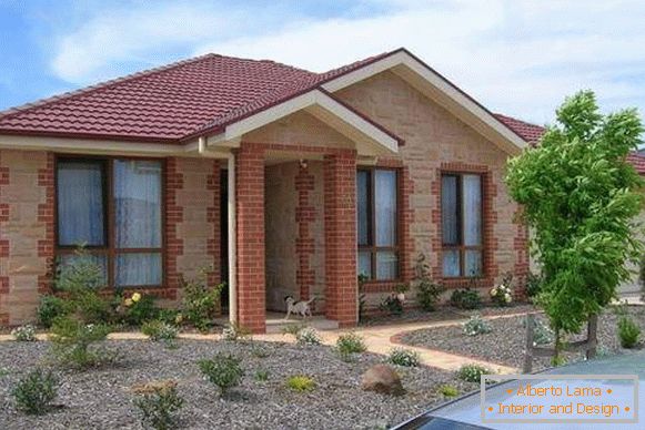 Finishing of the facade of a private house with brick and artificial stone