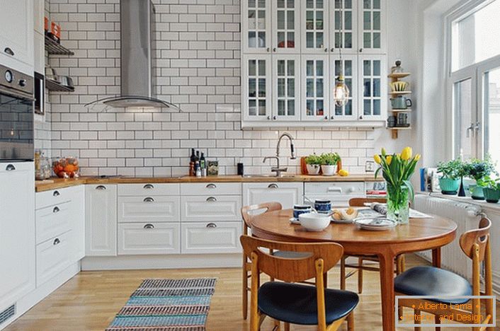 The interior of the kitchen is made in the Scandinavian style, which is expressed in a white, calm design. 