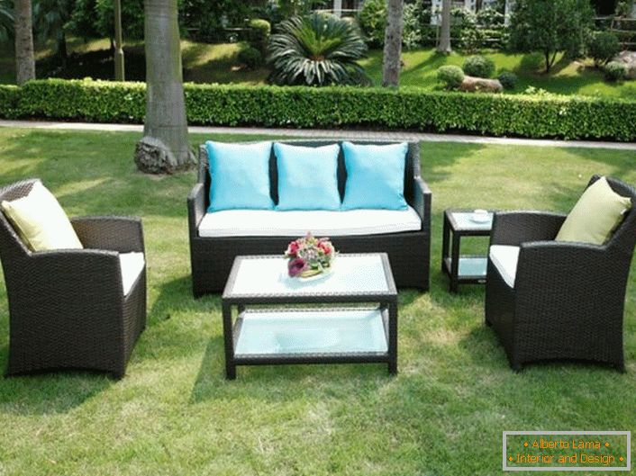 Original furniture made of artificial rattan is ideal for a garden plot.