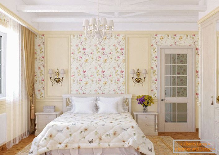 The walls of the bedroom in the country style are decorated with floral wallpaper, which blend harmoniously with the bedspread on the bed.