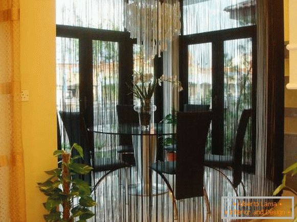 Black thread curtains in the kitchen interior with a bay window