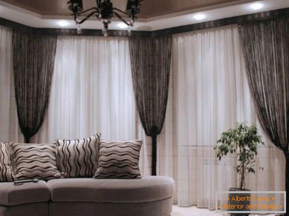 Black curtains in the interior of the living room with tulle