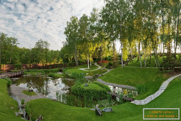 An artificial pond behind the house, which is decorated in the style of a chalet. An unusual, bold solution for the design of landscape design.