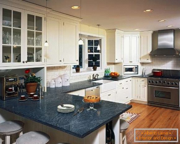 Kitchen interior in a private house - white furniture and black countertops