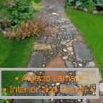 Large and small natural stones in the design of the garden path