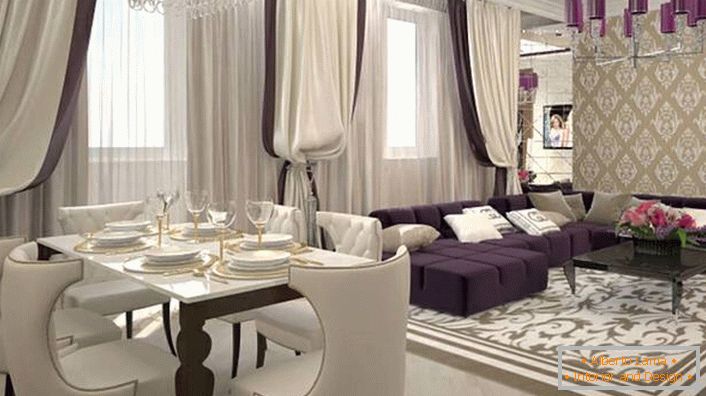 Heavy curtains on the windows in combination with soft white-lilac furniture combine to recreate the interior in the style of art deco. In accordance with the style, lighting is also selected. The ceiling chandelier is decorated with the same glossy shades of dark purple.