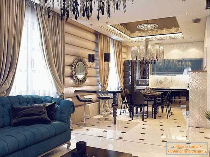 The pompous interior of the studio apartment in the Art Deco style is decorated with heavy curtains of dense fabric and a ceiling chandelier with a huge number of small, thin chains. 