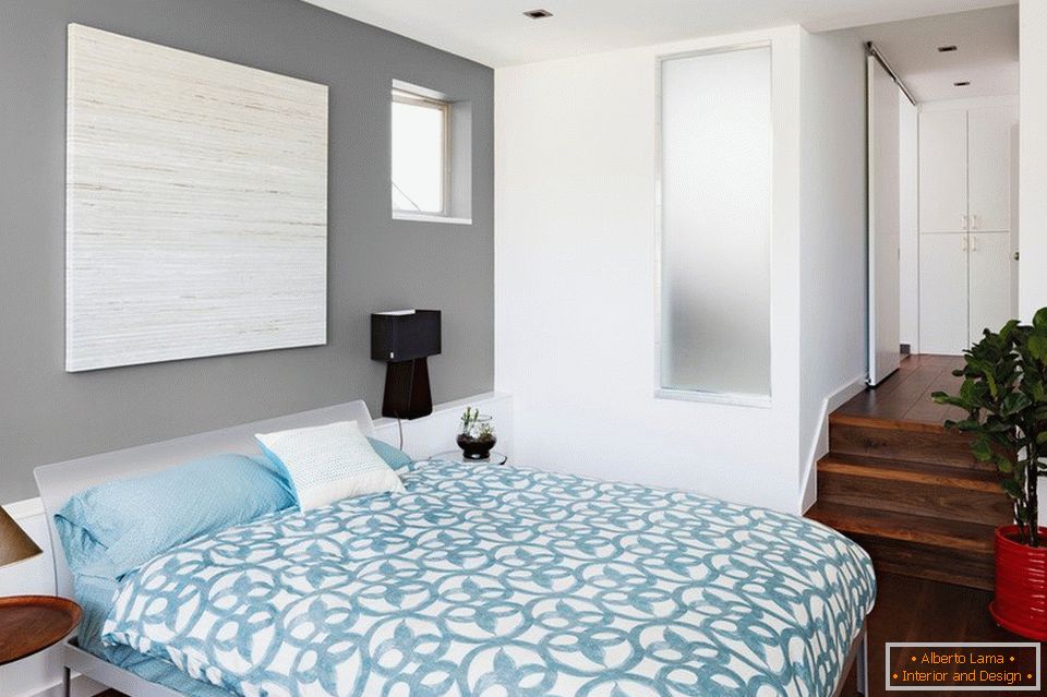 Blue linens and gray walls in the bedroom