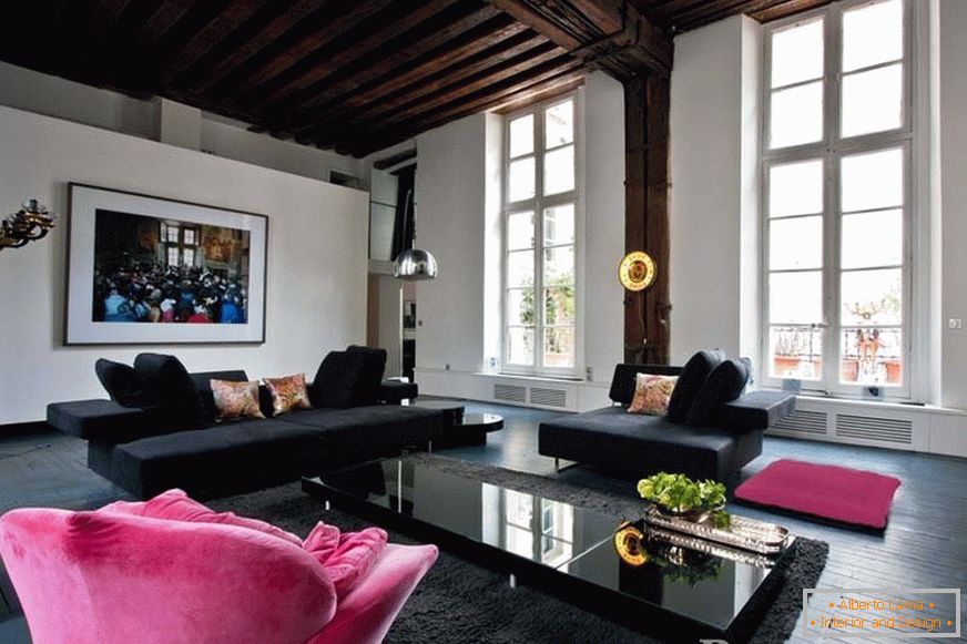 Black sofas and a pink armchair in the room