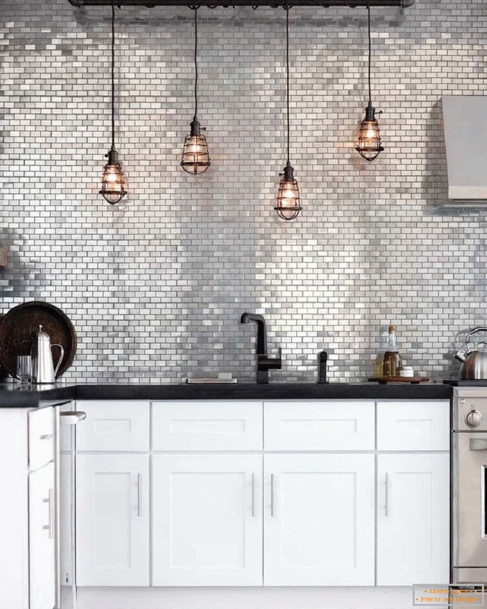 Kitchen in grunge style with an apron of silver color and retro lights above the working area