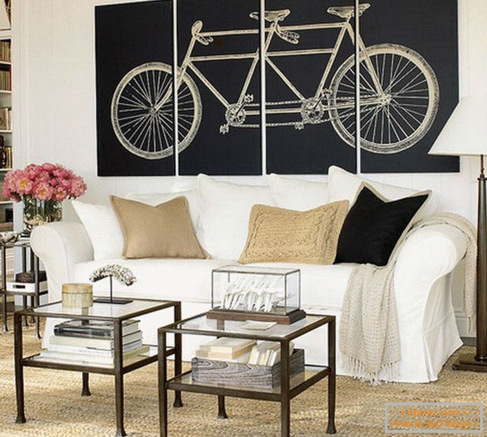 The living room in the Scandinavian style is decorated with modular paintings depicting a bicycle. Not overloaded with meaning, the design makes the design complete. 