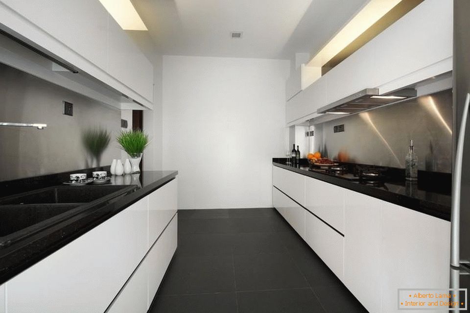 A narrow and long white kitchen with a black floor