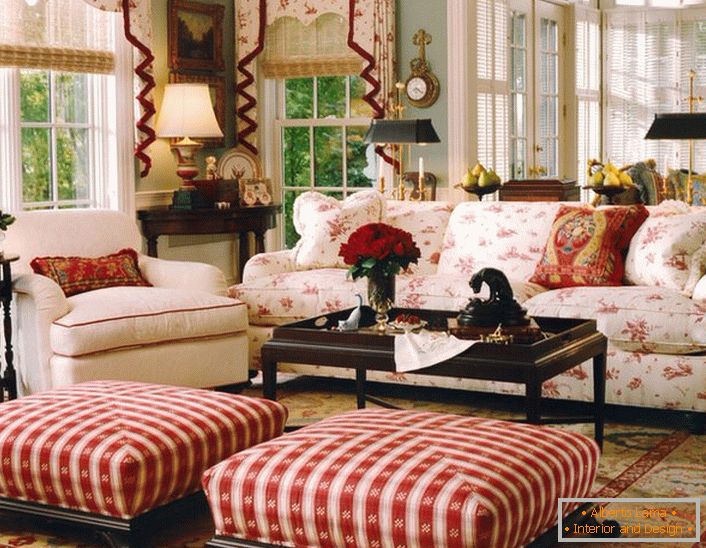 A simple, modest and cozy living room in English style in a small country house. Accents of red make the atmosphere in the room relaxed and cheerful.
