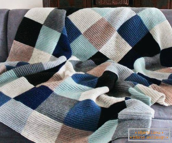 Handsome knitted plaid on the sofa with your hands