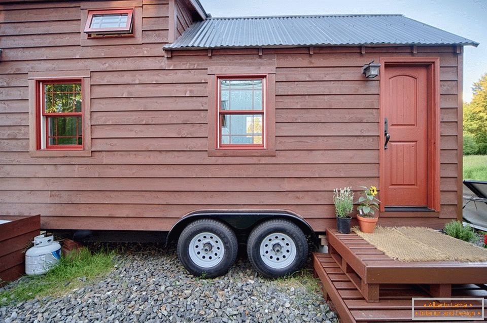 Entrance door of a small wooden cottage on wheels