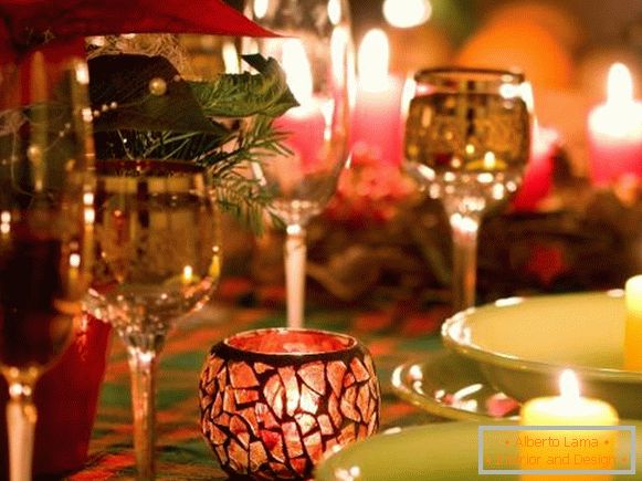 Beautiful glasses and candles in the decor of the New Year's table