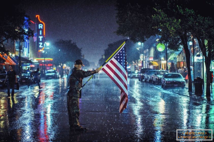 American patriot with flag outdoors in the rain