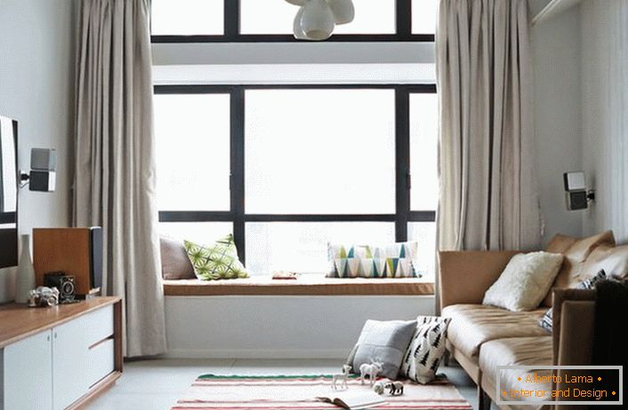 Simple single-color curtains of calm light colors are ideal for a spacious complex window, divided into sections. A room in Scandinavian style for a young man whose world of music and computer. 