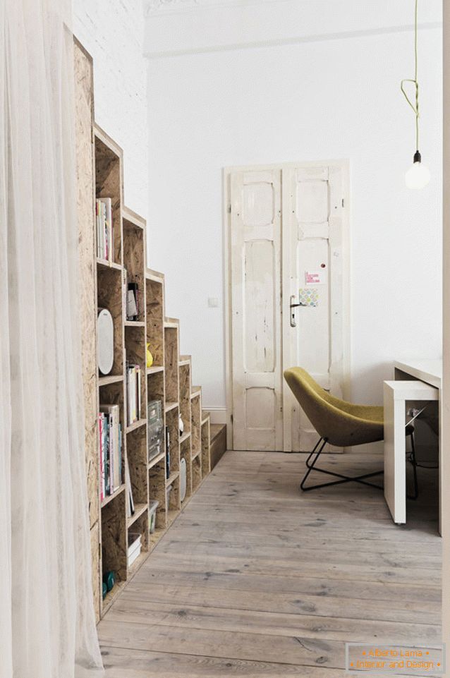 Shelving under a staircase in a two-story studio apartment